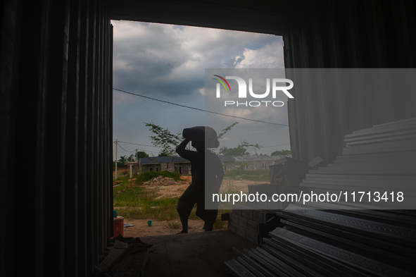 Porters load sacks of cement at the port of Belawan for the USU Residence III housing complex in Patumbak, Deli Serdang, North Sumatra, on O...