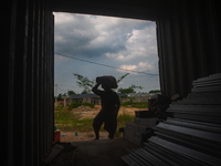 Porters load sacks of cement at the port of Belawan for the USU Residence III housing complex in Patumbak, Deli Serdang, North Sumatra, on O...