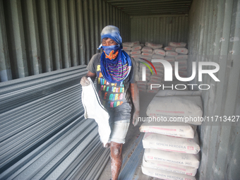 Porters load sacks of cement at the port of Belawan for the USU Residence III housing complex in Patumbak, Deli Serdang, North Sumatra, on O...