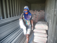 Porters load sacks of cement at the port of Belawan for the USU Residence III housing complex in Patumbak, Deli Serdang, North Sumatra, on O...