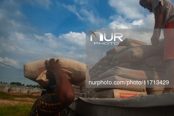 Porters load sacks of cement at the port of Belawan for the USU Residence III housing complex in Patumbak, Deli Serdang, North Sumatra, on O...