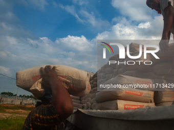 Porters load sacks of cement at the port of Belawan for the USU Residence III housing complex in Patumbak, Deli Serdang, North Sumatra, on O...