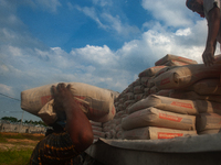 Porters load sacks of cement at the port of Belawan for the USU Residence III housing complex in Patumbak, Deli Serdang, North Sumatra, on O...