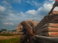 Porters load sacks of cement at the port of Belawan for the USU Residence III housing complex in Patumbak, Deli Serdang, North Sumatra, on O...