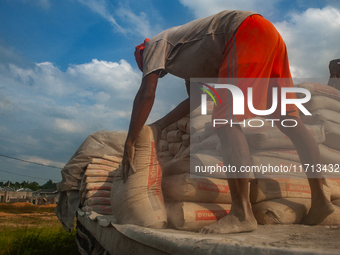 Porters load sacks of cement at the port of Belawan for the USU Residence III housing complex in Patumbak, Deli Serdang, North Sumatra, on O...