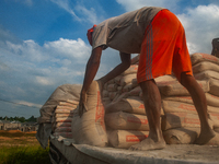 Porters load sacks of cement at the port of Belawan for the USU Residence III housing complex in Patumbak, Deli Serdang, North Sumatra, on O...