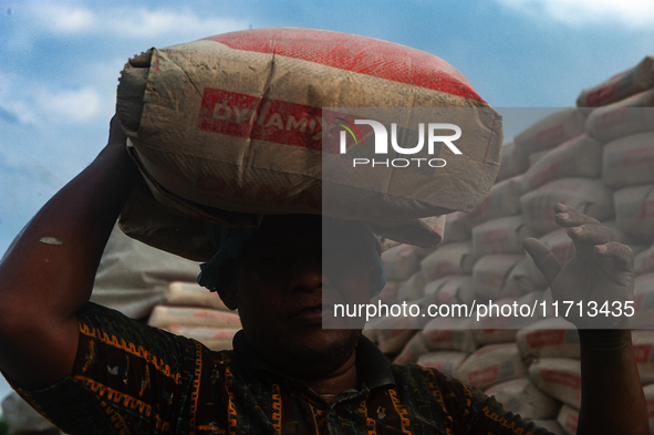 Porters load sacks of cement at the port of Belawan for the USU Residence III housing complex in Patumbak, Deli Serdang, North Sumatra, on O...