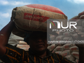 Porters load sacks of cement at the port of Belawan for the USU Residence III housing complex in Patumbak, Deli Serdang, North Sumatra, on O...