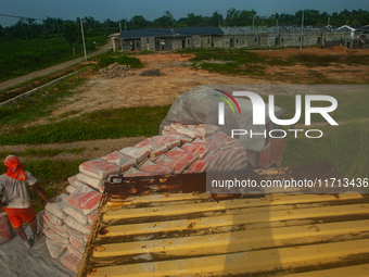 Porters load sacks of cement at the port of Belawan for the USU Residence III housing complex in Patumbak, Deli Serdang, North Sumatra, on O...