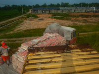 Porters load sacks of cement at the port of Belawan for the USU Residence III housing complex in Patumbak, Deli Serdang, North Sumatra, on O...