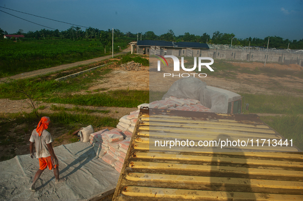 Porters load sacks of cement at the port of Belawan for the USU Residence III housing complex in Patumbak, Deli Serdang, North Sumatra, on O...