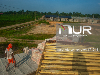 Porters load sacks of cement at the port of Belawan for the USU Residence III housing complex in Patumbak, Deli Serdang, North Sumatra, on O...