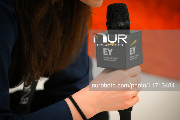 A woman holds a microphone with an Ernst and Young logo at the opening of the new Museum of Modern Art (Muzeum Sztuki Nowoczesnej) in Warsaw...