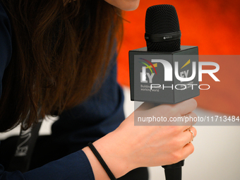 A woman holds a microphone with an Ernst and Young logo at the opening of the new Museum of Modern Art (Muzeum Sztuki Nowoczesnej) in Warsaw...