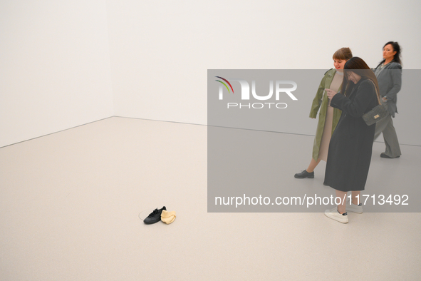 Visitors take a photo of a shoe and a hat on the floor of the new Museum of Modern Art (Muzeum Sztuki Nowoczesnej) in Warsaw, Poland on 25 O...