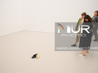 Visitors take a photo of a shoe and a hat on the floor of the new Museum of Modern Art (Muzeum Sztuki Nowoczesnej) in Warsaw, Poland on 25 O...