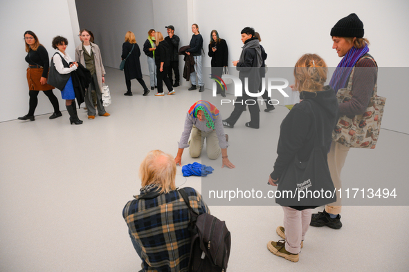 An elderly man performs while people watch at the opening of the new Museum of Modern Art (Muzeum Sztuki Nowoczesnej) in Warsaw, Poland on 2...