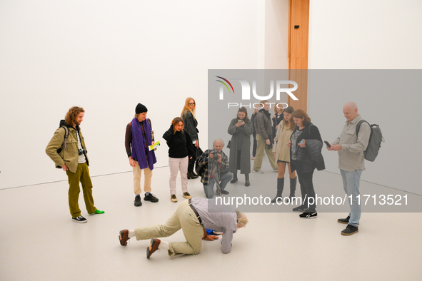 An elderly man performs while people watch at the opening of the new Museum of Modern Art (Muzeum Sztuki Nowoczesnej) in Warsaw, Poland on 2...