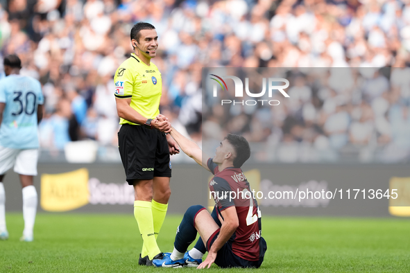 Referee Marco Piccinini helps Johan Vasquez of Genoa CFC get up during the Serie A Enilive match between SS Lazio and Genoa CF at Stadio Oli...