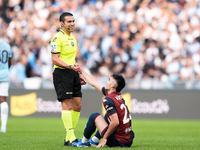 Referee Marco Piccinini helps Johan Vasquez of Genoa CFC get up during the Serie A Enilive match between SS Lazio and Genoa CF at Stadio Oli...