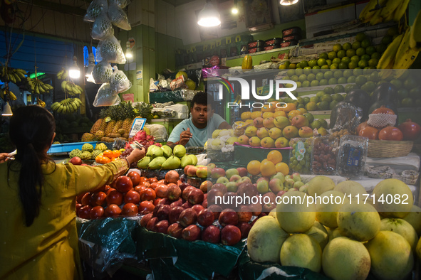 A woman buys fruits inside a market in Kolkata, India, on October 27, 2024. 