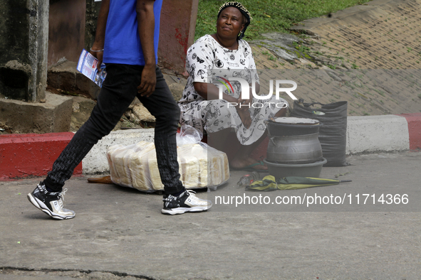 An official with a sensitization leaflet walks past a street food vendor as the Federal Nigeria Society for the Blind organizes a walk and c...