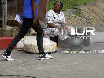 An official with a sensitization leaflet walks past a street food vendor as the Federal Nigeria Society for the Blind organizes a walk and c...