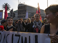 People hold signs and shout slogans as they rally against the Polish Prime Minister Donald Tusk's decision to suspend the right to asylum wi...