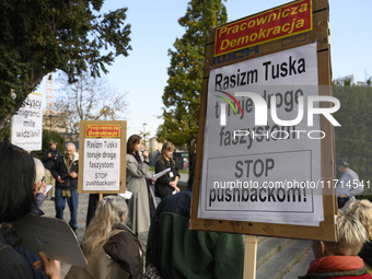 People hold signs that read ''Tusk's racism opens a path to fascists - STOP pushbacks!'' and shout slogans as they rally against the Polish...