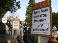 People hold signs that read ''Tusk's racism opens a path to fascists - STOP pushbacks!'' and shout slogans as they rally against the Polish...