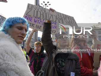 Demonstrators hold a sign that reads ''Ukrainians in solidarity with world's refugees'' and shout slogans as they rally against the Polish P...