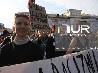 People hold signs that read ''Let in migrants, deport nationalists'' and shout slogans as they rally against the Polish Prime Minister Donal...