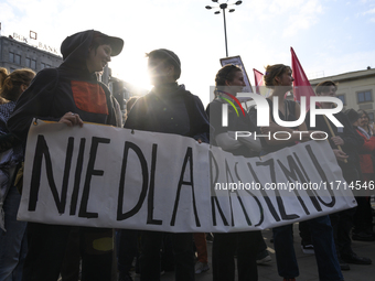 People hold a banner that reads ''No to racism'' as they rally against the Polish Prime Minister Donald Tusk's decision to suspend the right...