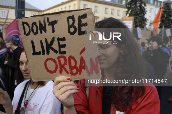 A demonstrator holds a sign that reads ''Do not be like Orban'' during a rally against the Polish Prime Minister Donald Tusk's decision to s...