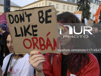 A demonstrator holds a sign that reads ''Do not be like Orban'' during a rally against the Polish Prime Minister Donald Tusk's decision to s...