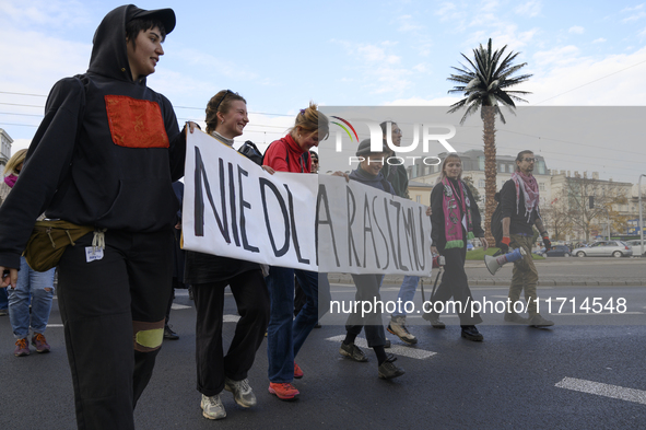 People hold a banner that reads ''No to racism'' as they rally against the Polish Prime Minister Donald Tusk's decision to suspend the right...