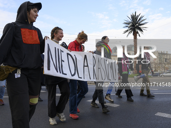 People hold a banner that reads ''No to racism'' as they rally against the Polish Prime Minister Donald Tusk's decision to suspend the right...