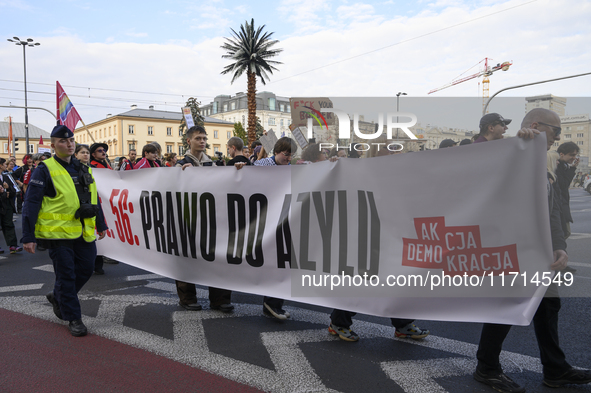 People carry a banner that reads ''Article 56: Right to asylum'' as they rally against the Polish Prime Minister Donald Tusk's decision to s...