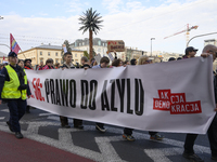 People carry a banner that reads ''Article 56: Right to asylum'' as they rally against the Polish Prime Minister Donald Tusk's decision to s...