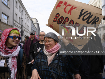 A demonstrator holds a sign that reads ''Fuck your border'' as she rallies against the Polish Prime Minister Donald Tusk's decision to suspe...