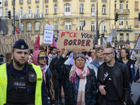 A demonstrator holds a sign that reads ''Fuck your border'' as she rallies against the Polish Prime Minister Donald Tusk's decision to suspe...