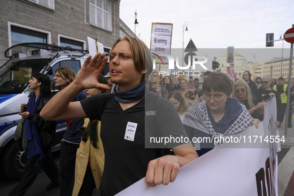 People hold signs and shout slogans as they rally against the Polish Prime Minister Donald Tusk's decision to suspend the right to asylum wi...