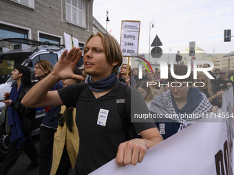 People hold signs and shout slogans as they rally against the Polish Prime Minister Donald Tusk's decision to suspend the right to asylum wi...