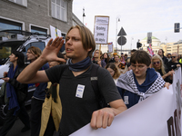 People hold signs and shout slogans as they rally against the Polish Prime Minister Donald Tusk's decision to suspend the right to asylum wi...