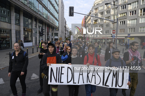 People hold a banner that reads ''No to racism'' as they rally against the Polish Prime Minister Donald Tusk's decision to suspend the right...