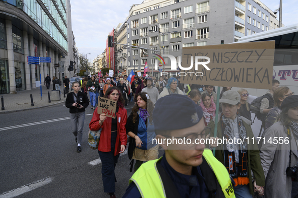 People hold signs that read ''Tusk destroys human rights'' and ''Do not be like Orban'' as they rally against the Polish Prime Minister Dona...