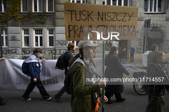 People hold signs that read ''Tusk destroys human rights'' as they rally against the Polish Prime Minister Donald Tusk's decision to suspend...