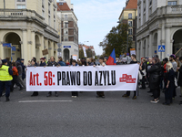 People carry a banner that reads ''Article 56: Right to asylum'' as they rally against the Polish Prime Minister Donald Tusk's decision to s...