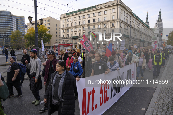 People hold signs and shout slogans as they rally against the Polish Prime Minister Donald Tusk's decision to suspend the right to asylum wi...