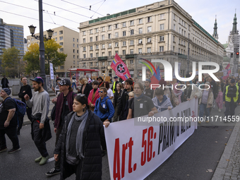 People hold signs and shout slogans as they rally against the Polish Prime Minister Donald Tusk's decision to suspend the right to asylum wi...